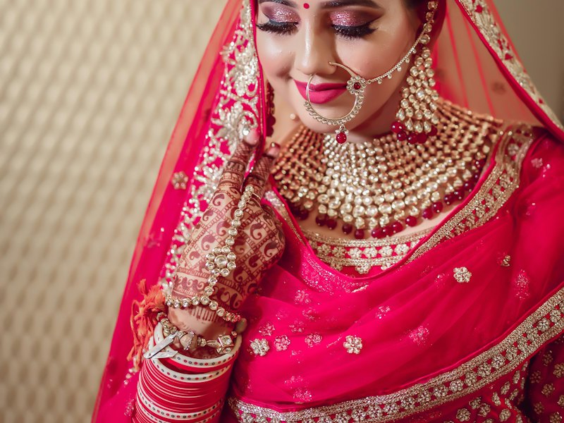 Bride in a red bridal outfit with gold embroidery